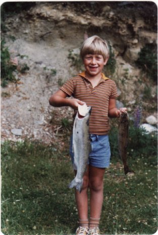 Graeme as a boy, proudly holds the fish he just caught