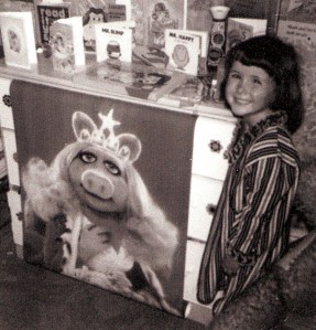 Black and white photo of small girl with her favourite Muppet merchandise