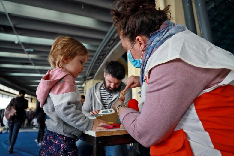 World Vision volunteer feeding a child refugee from Ukraine