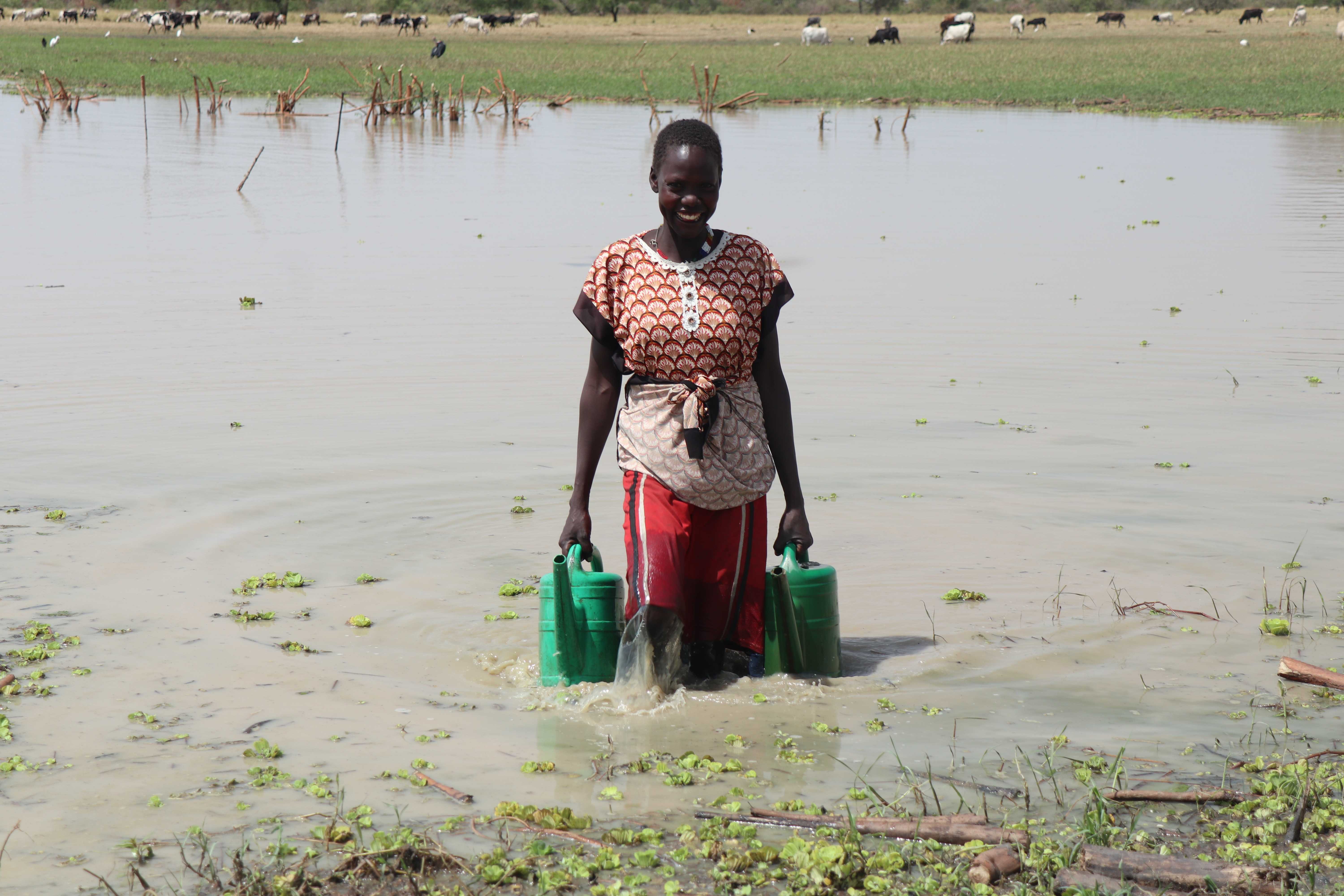 Ator collects buckets of water to irrigate her village's farm