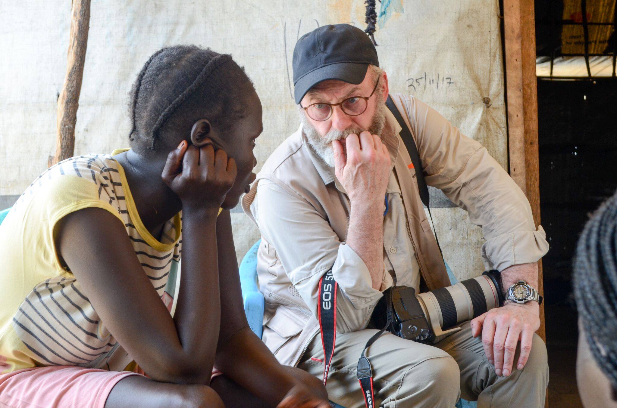 Liam Cunningham talking to a girl on his felid trip to Uganda 