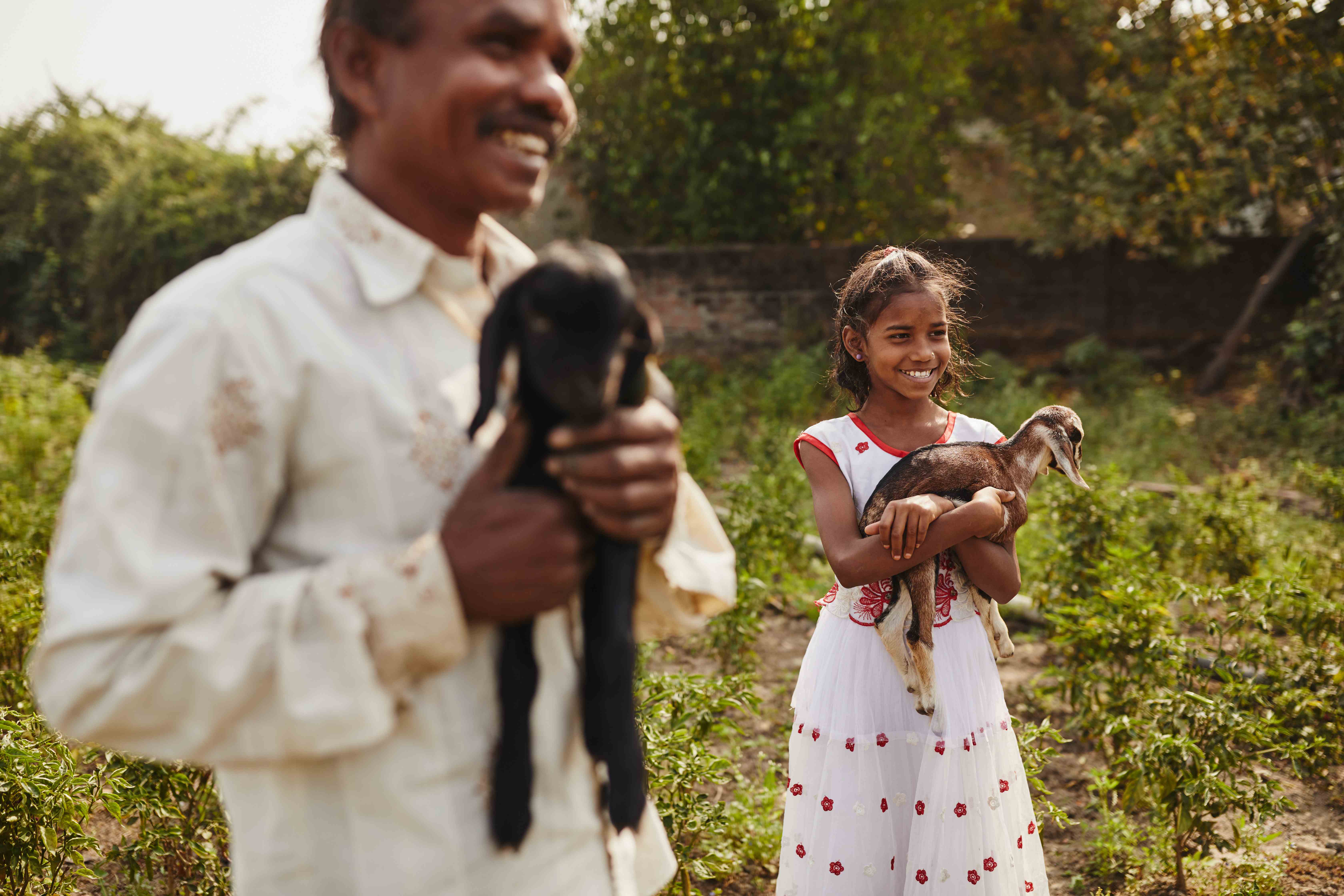 10 years old sponsored child Nargis enjoys playing with the baby goats. In this picture, she is seen along with her father. 