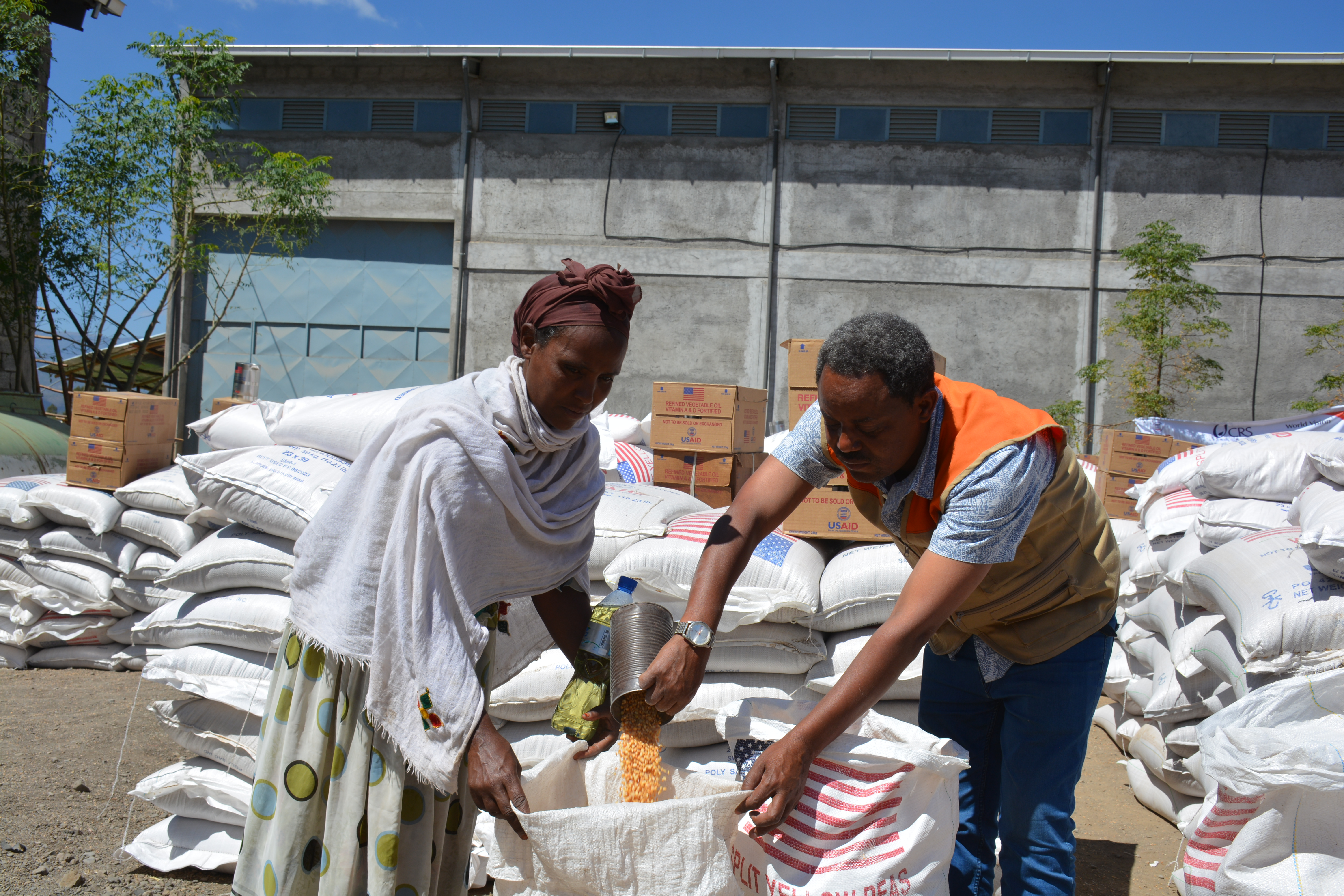 An Ethiopian mother receives food assistance from a World Vision volunteer