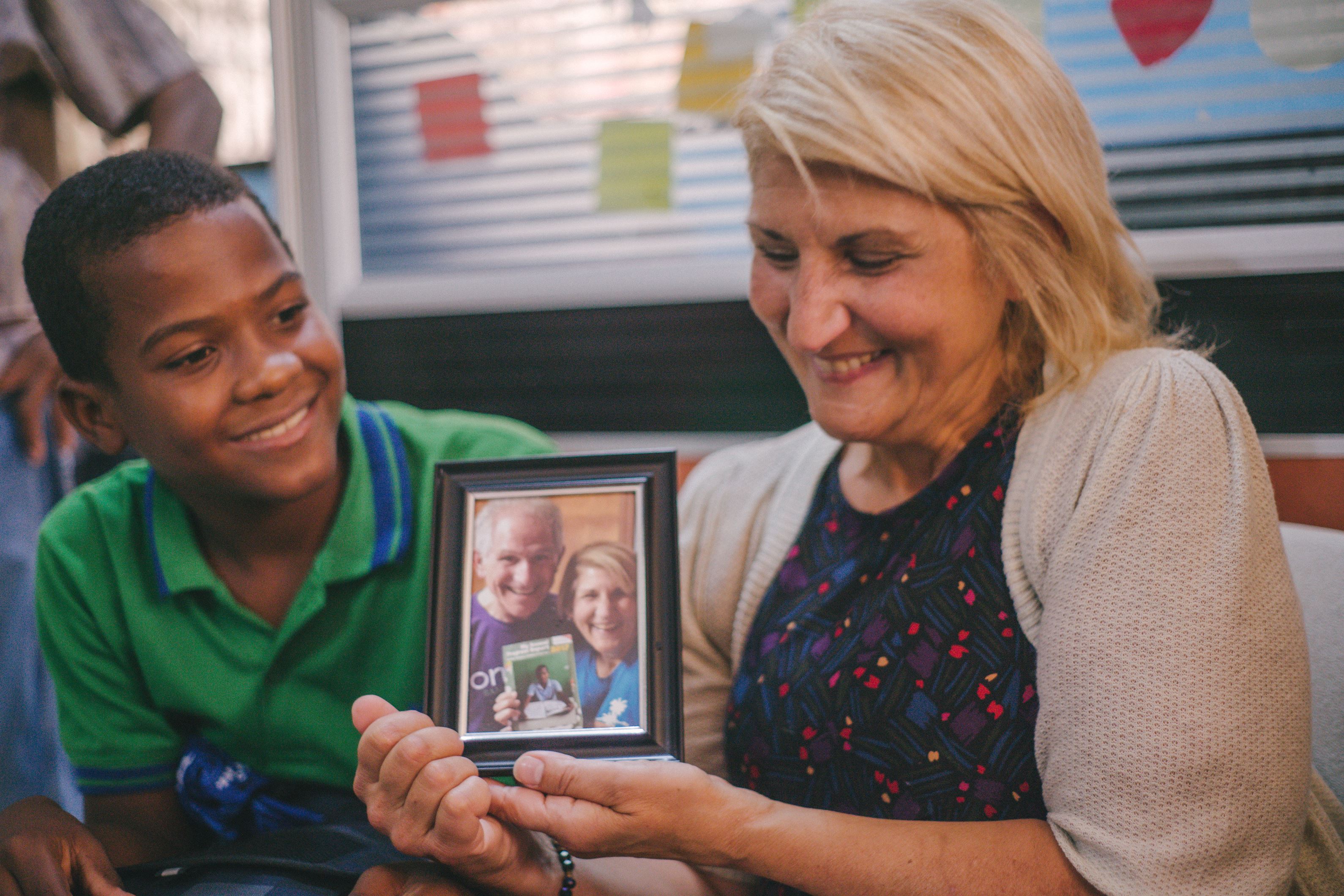 Boy meets his sponsor in the Dominican Republic, and she holds the picture of herself and her husband that he cherishes