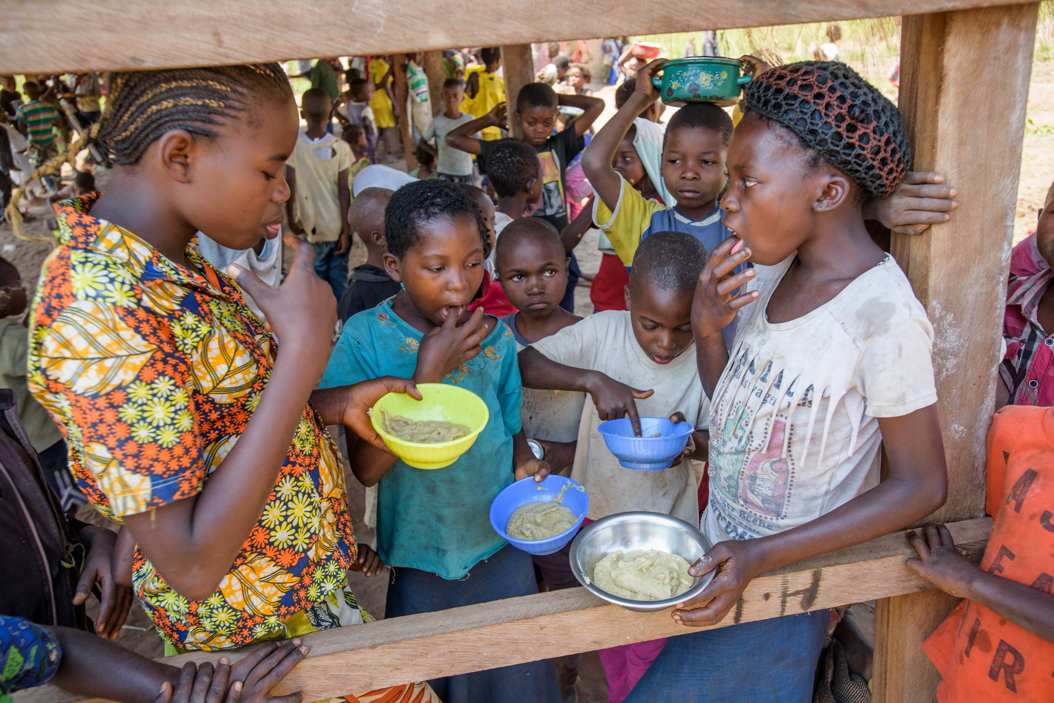Marie Ngalula, 14, from DRC eats nutritious porridge at a child friendly space near her home