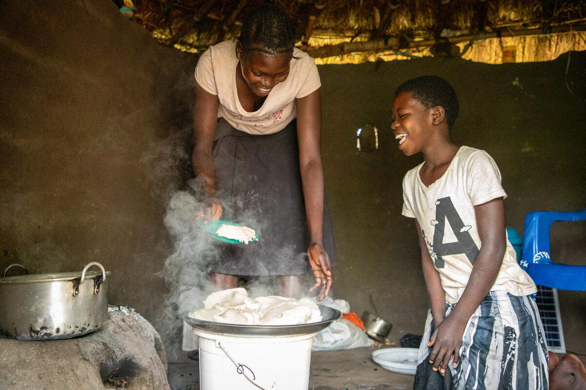 Viola preparing a favourite meal for her children, Schola and Robinah