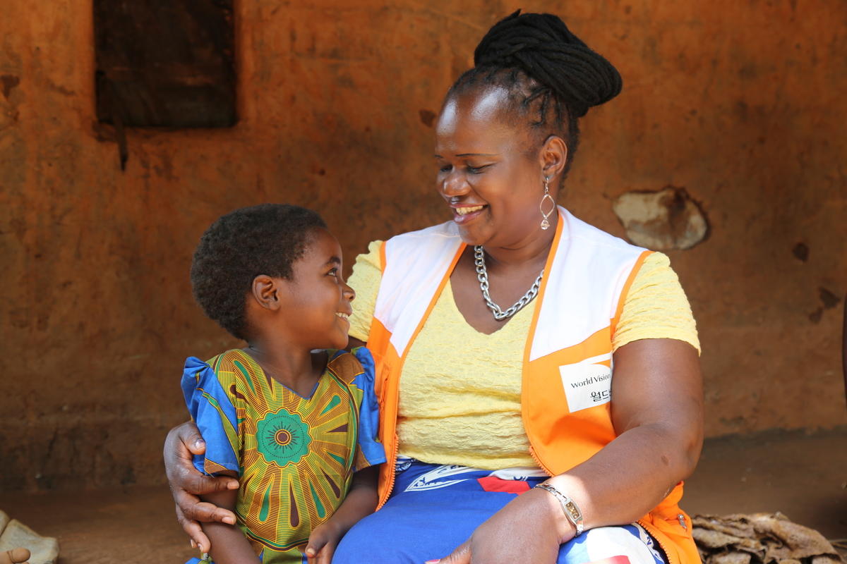 World Vision staff Chimwemwe Mizaya visiting a sponsored child Tonthozo in Ntchisi district in Malawi