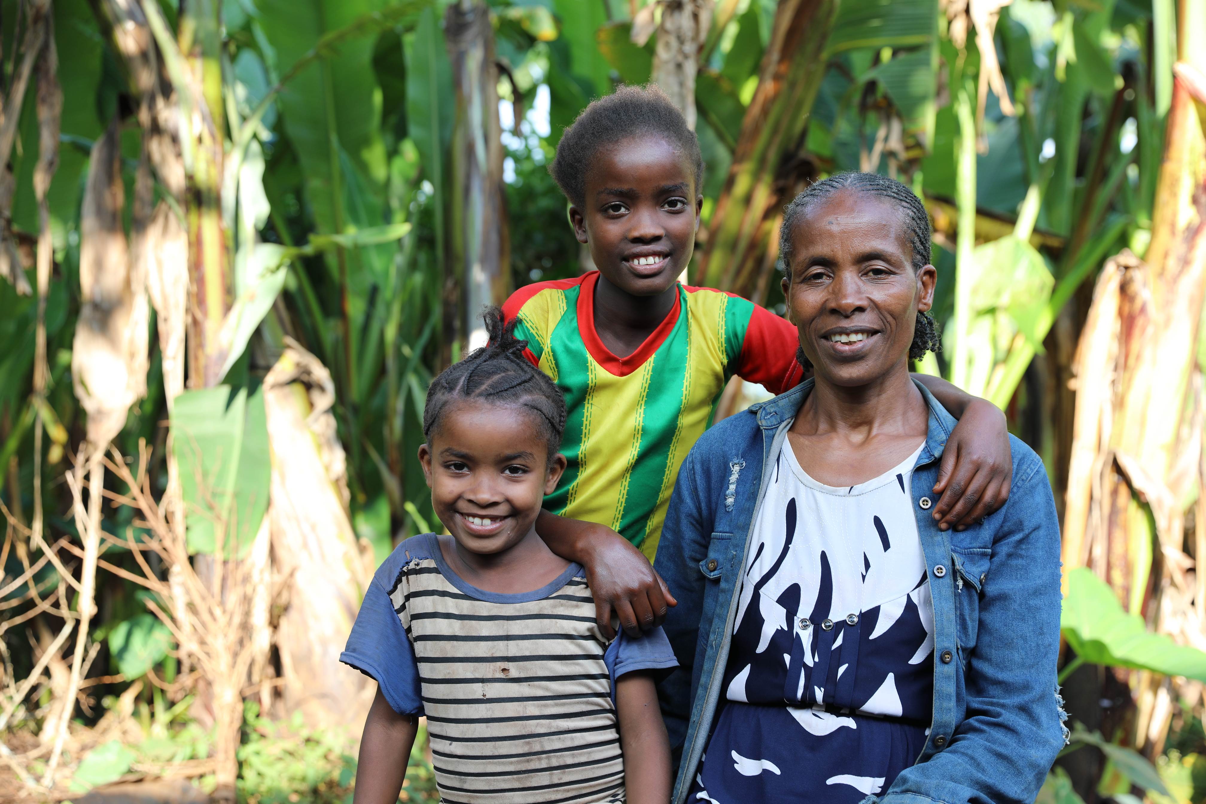 A mother from Ethiopia and her two daughters smile at the camera