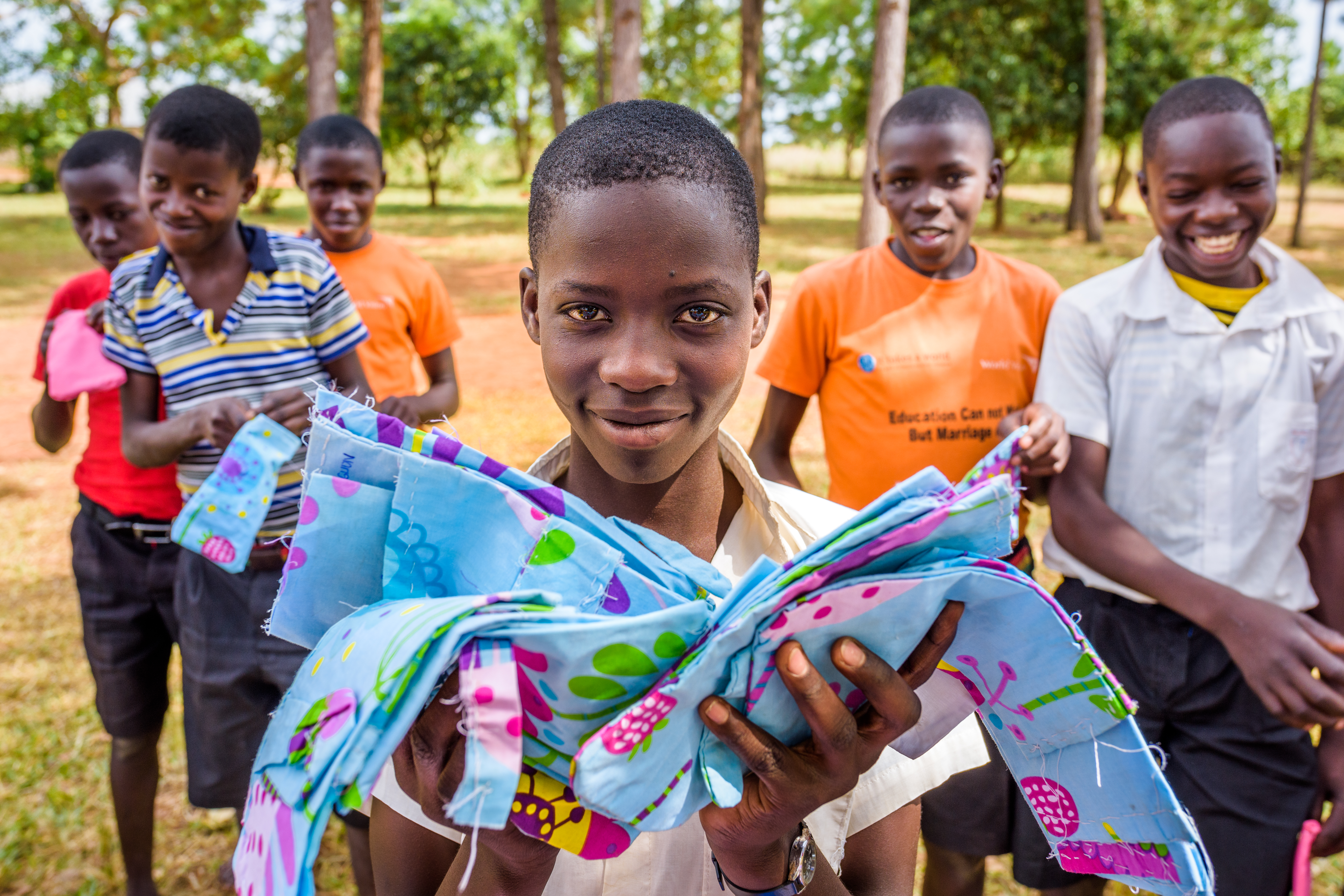 A group of Ugandan schoolboys showing off the reusable sanitary pads they created in class.