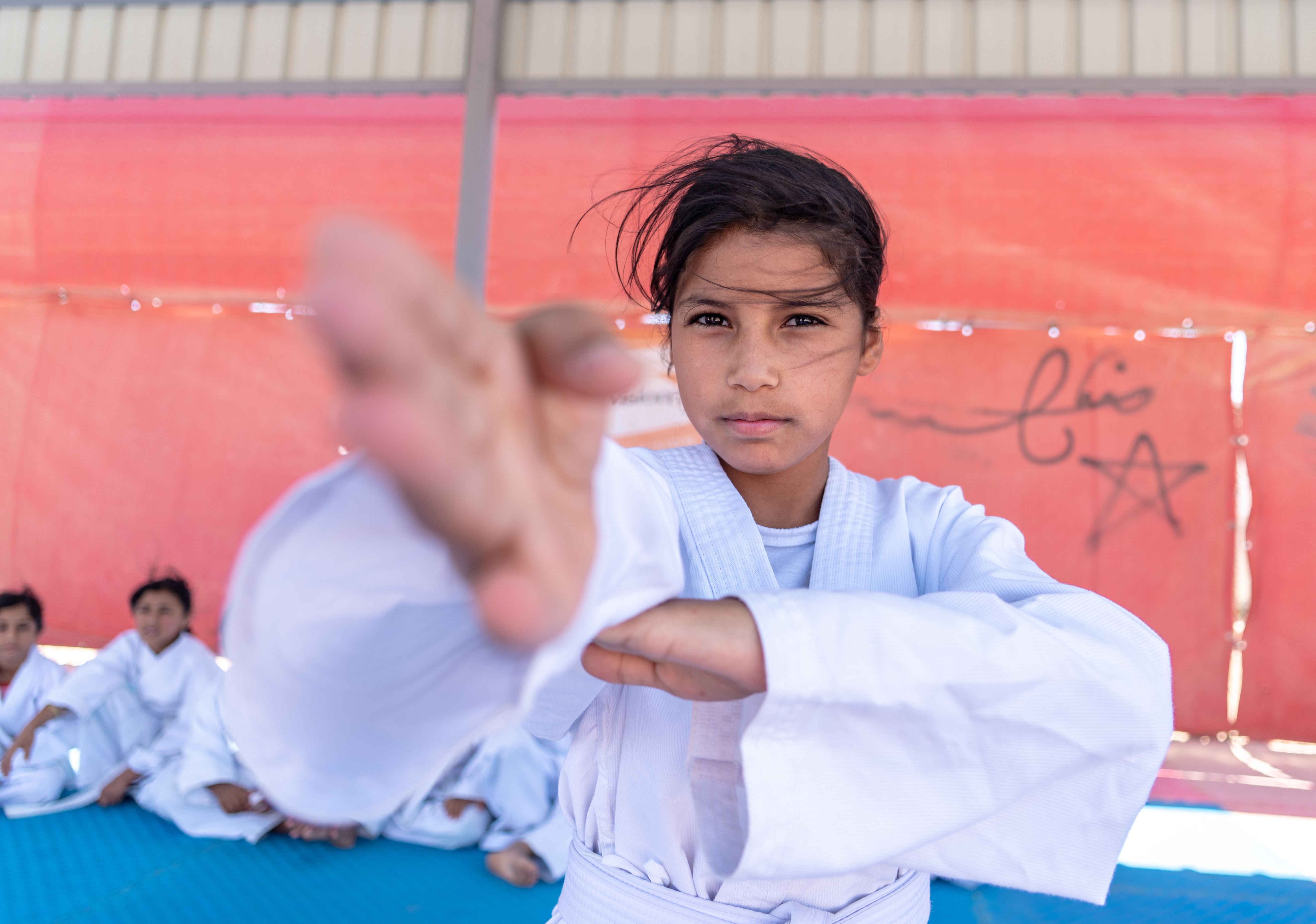A Syrian girl shows her technique to the camera as she takes part in a karate class in Jordan's Azraq refugee camp