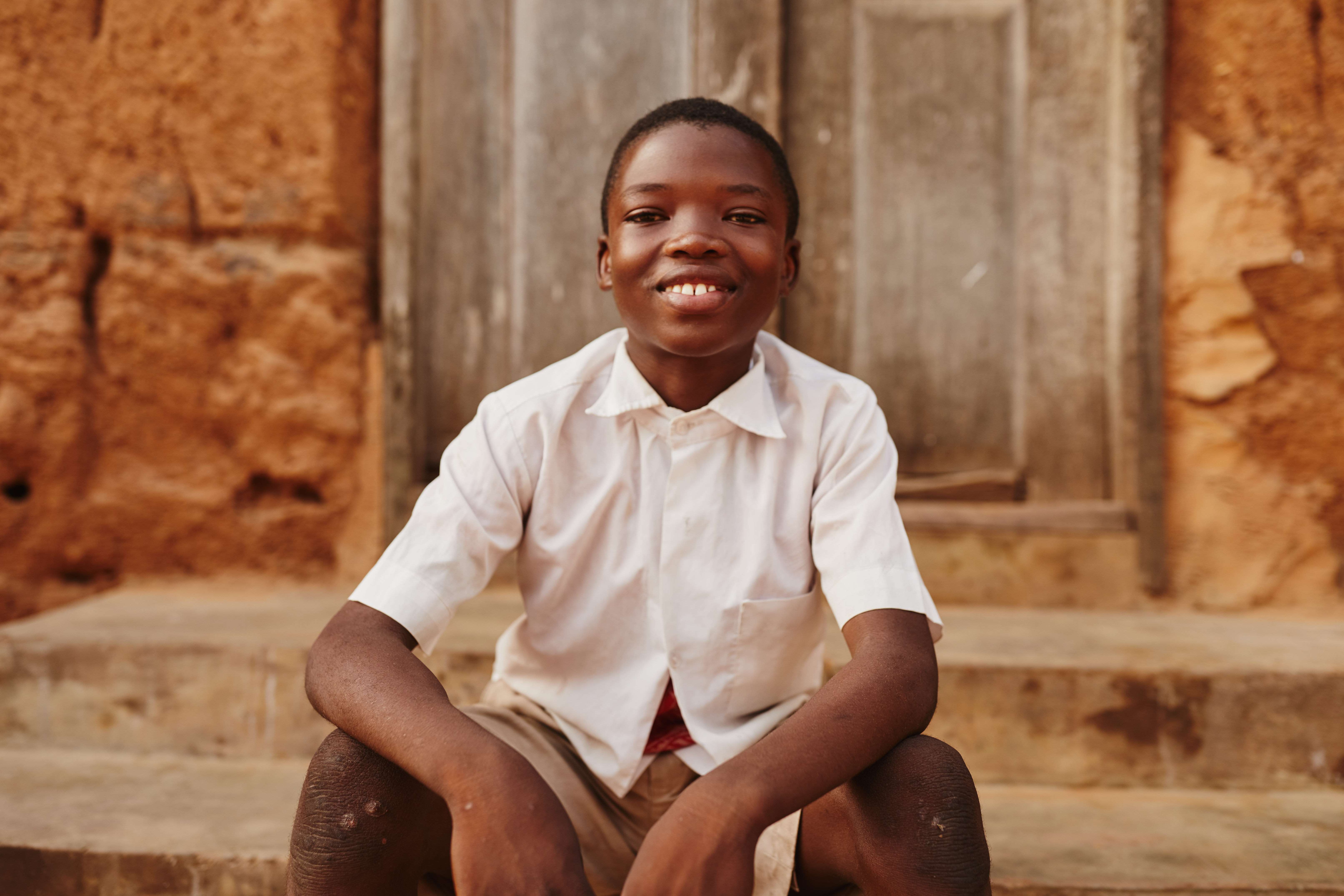 A sponsored child sitting on a step 