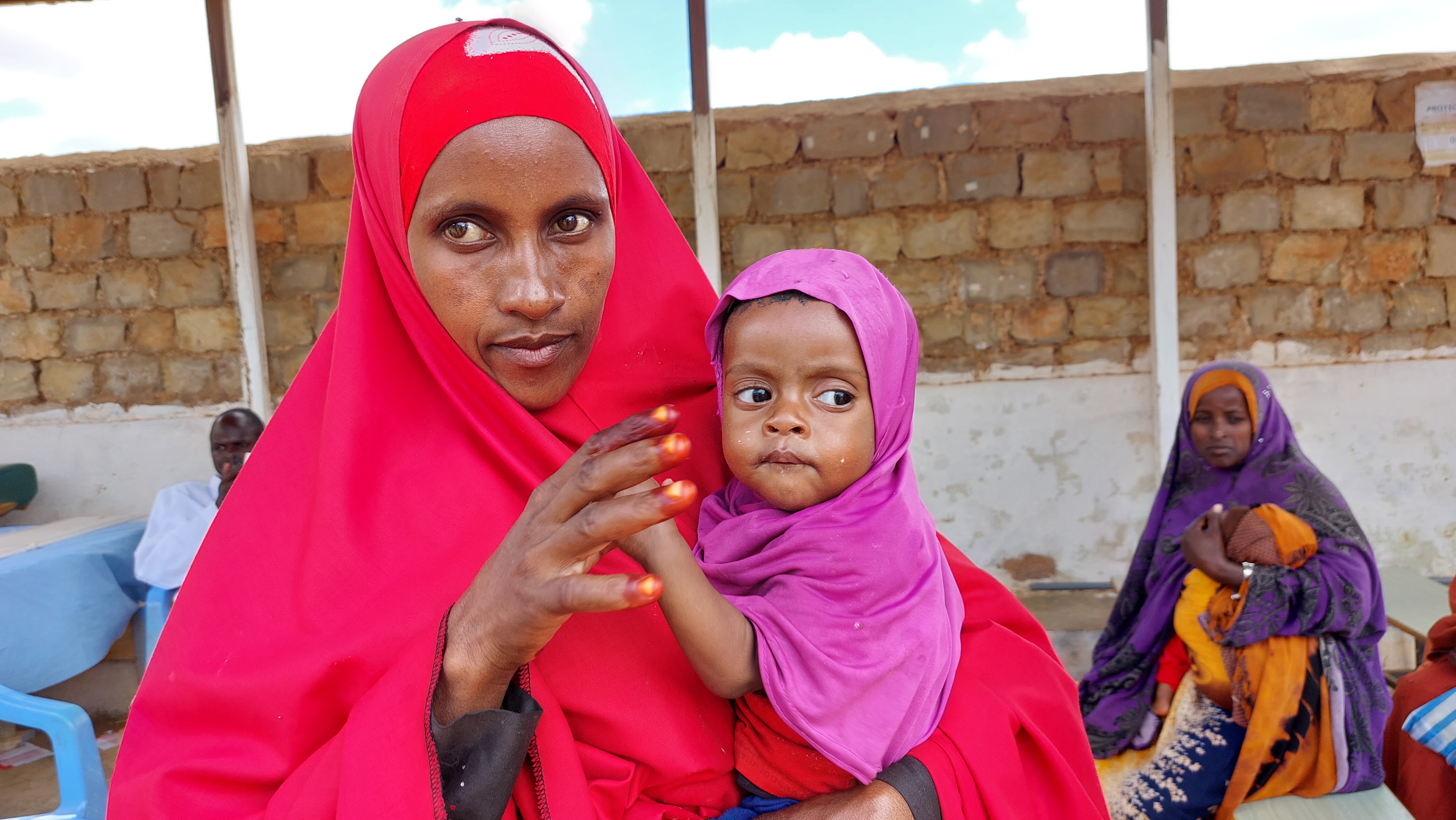 Somali woman wearing a hijab holding her young daughter.