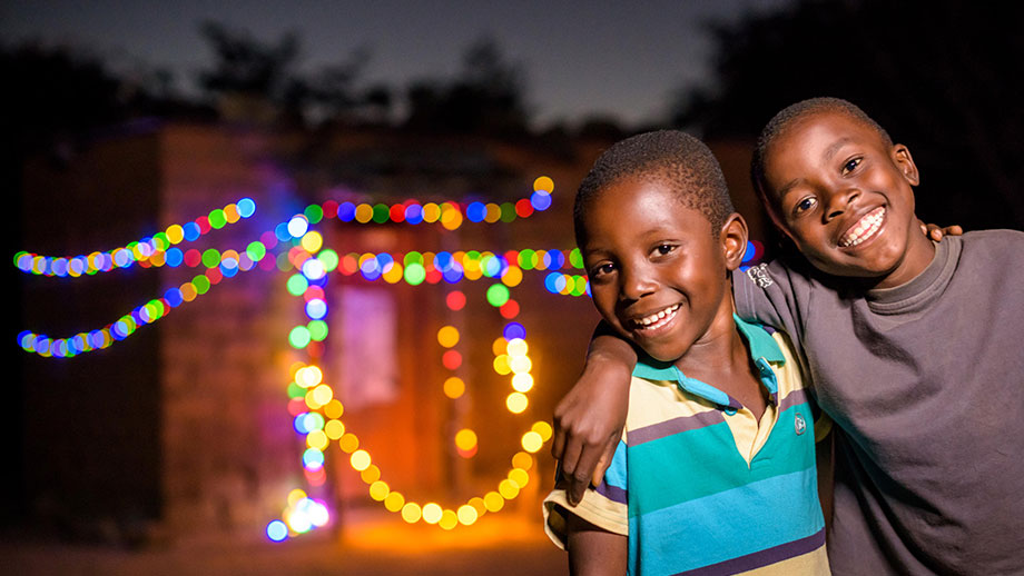 Sponsored boy Chansa, 5, from Zambia, enjoys Christmas lights strung up on his grandfather's house