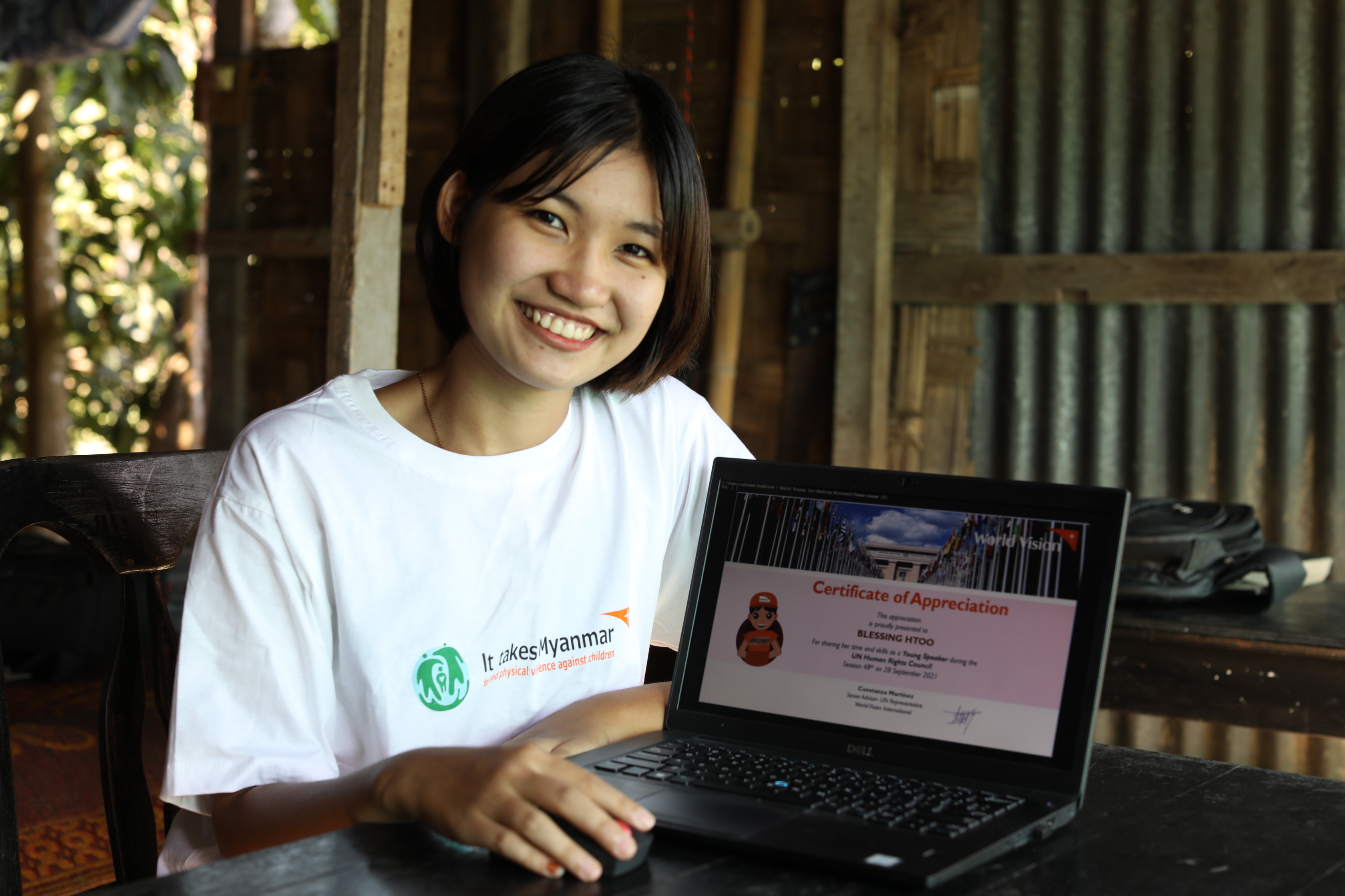 Sponsored child Blessing from Myanmar smiles as she looks at the camera while using her laptop