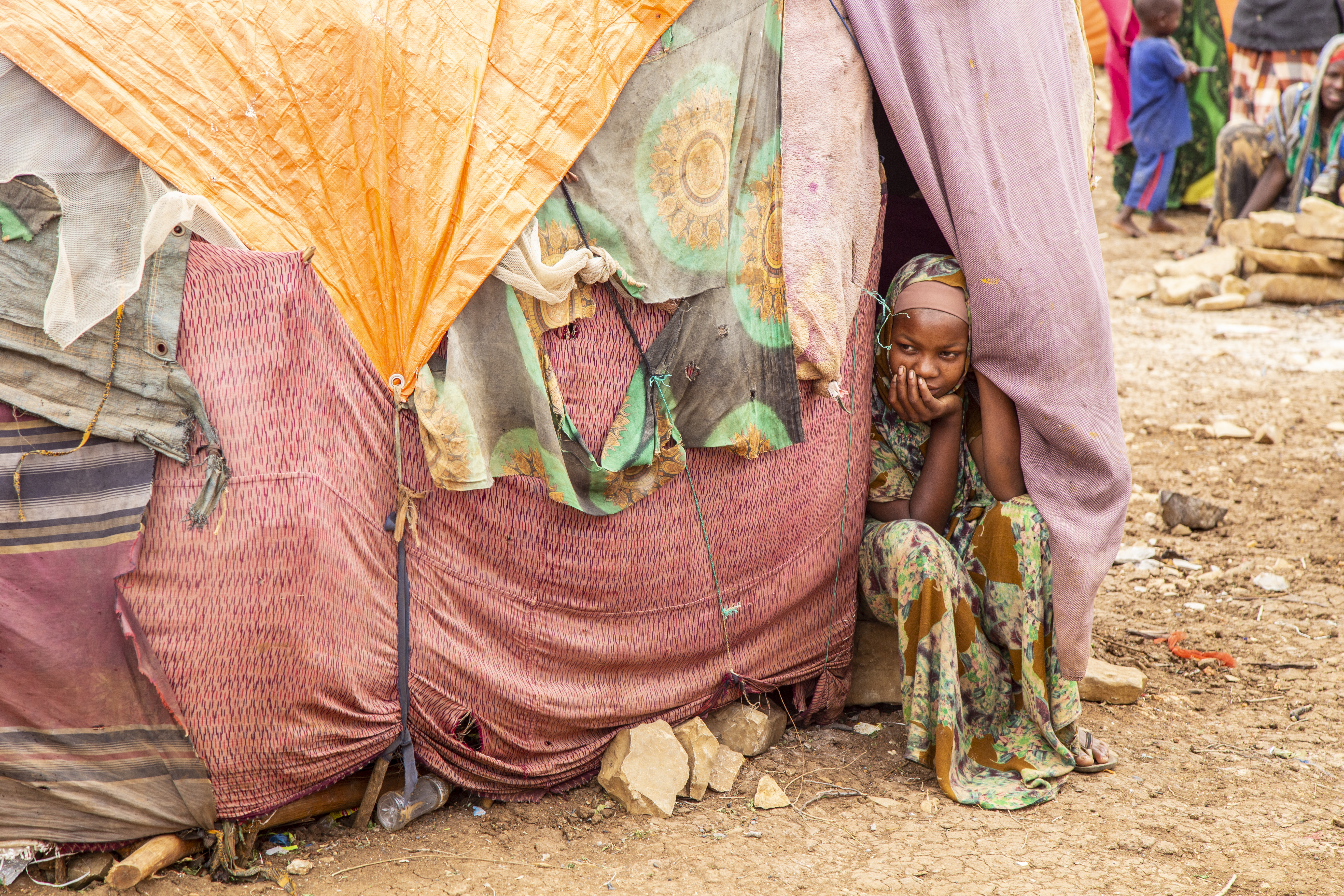 Displaced Somalian child in the Baidoa camp peeks out of a makeshift shelter her family has been living in