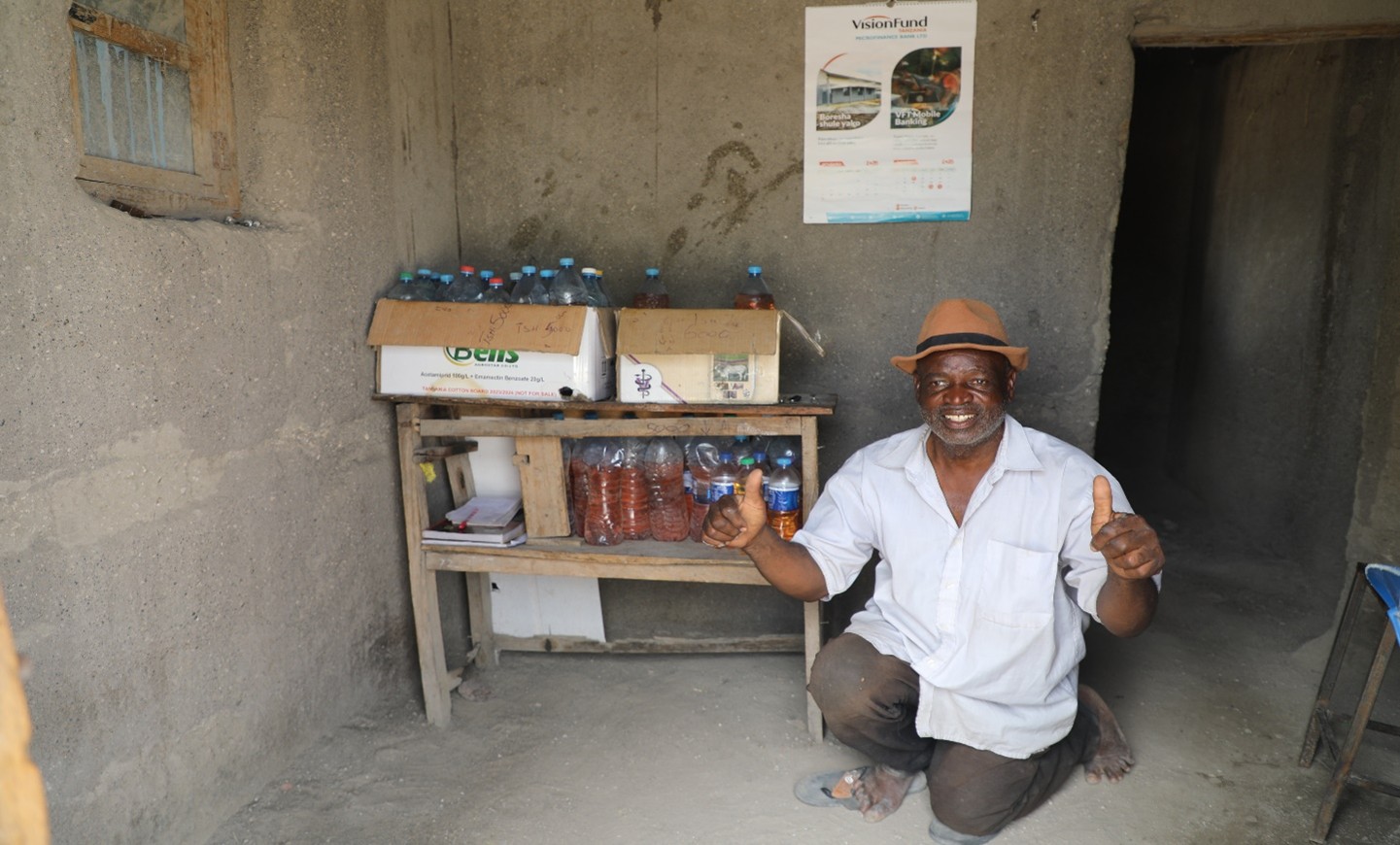 Mr. Ngassa smiles in front of his petrol selling business after securing a loan from Vision Fund