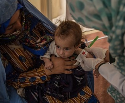 A child in Afghanistan is tested for malnutrition using a MUAC tape.