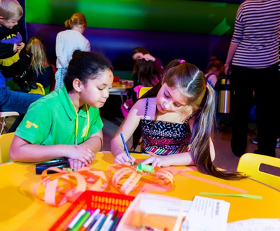 Two kids are sitting in a table and learning something