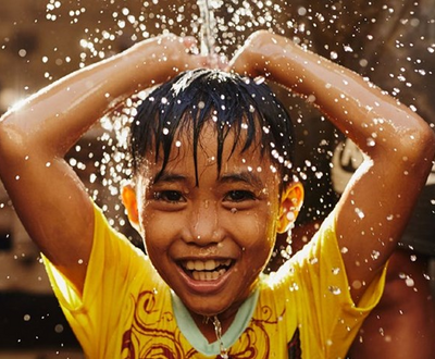 A boy poring water through his head
