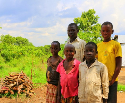 5 Ugandan people stand outside a health facility