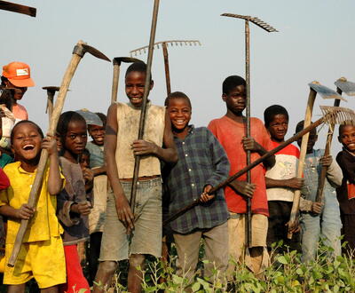 Children pose with their parents’ farm tools.