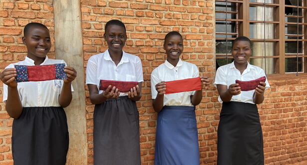 Girls holding reusable feminine hygienic kits at Rukana secondary school