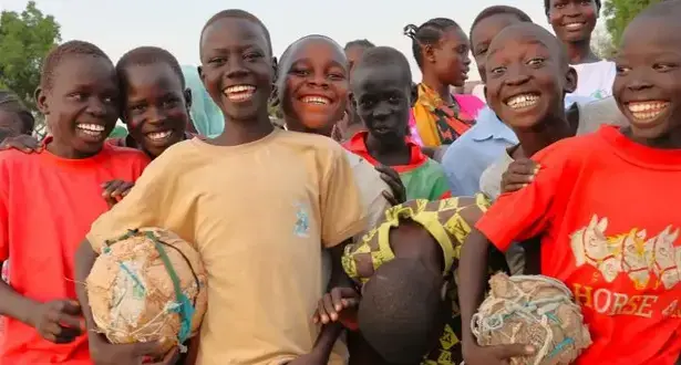 Smiling Sudanese boys with football