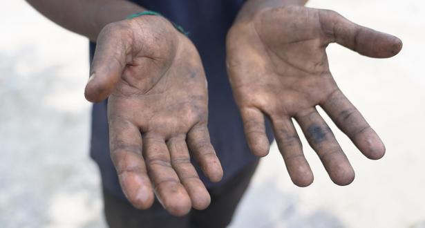 Dirty hand of Sajal after servicing a motor bike in the workshop.
