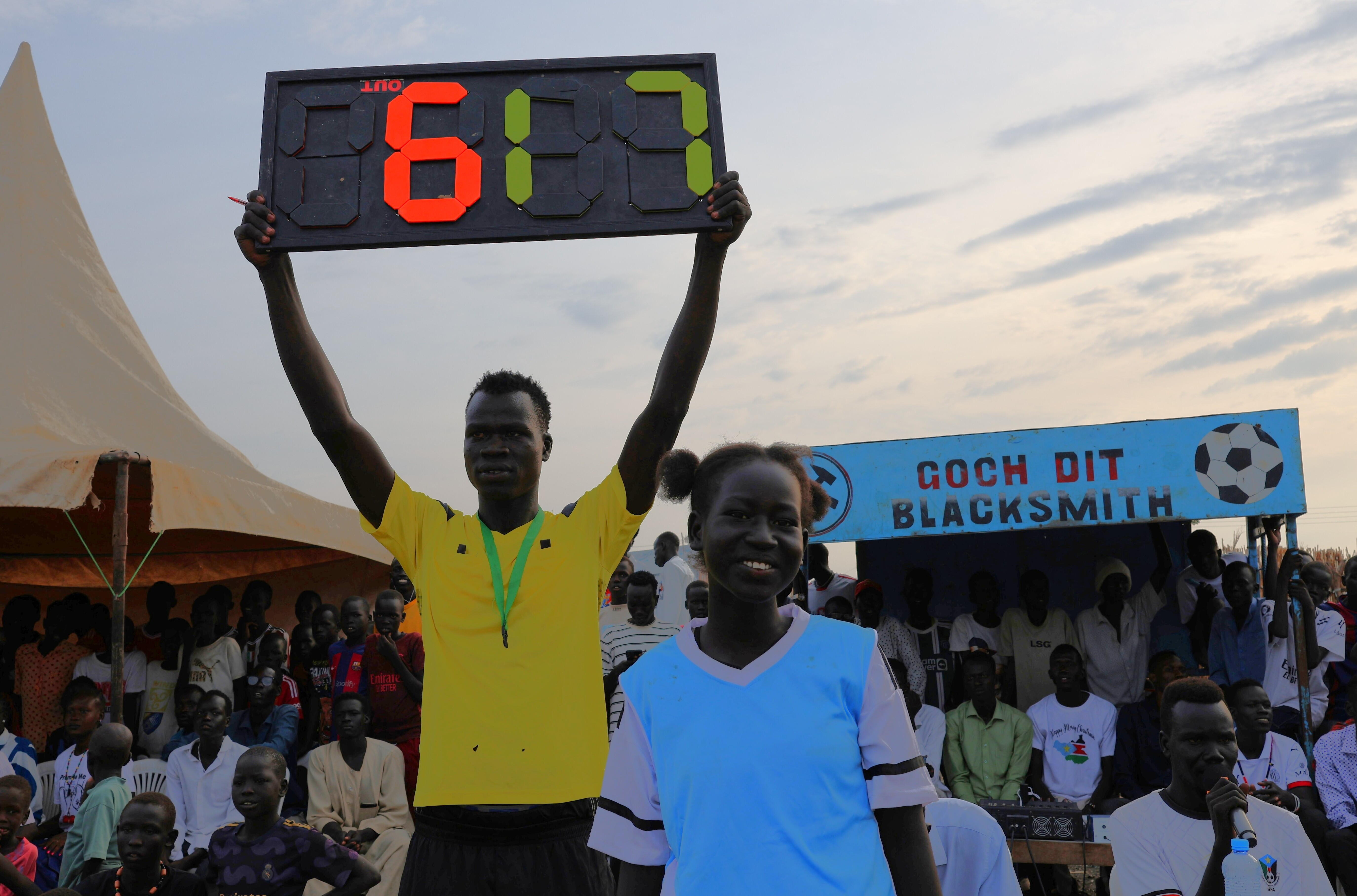 Sudanese man holding scoreboard