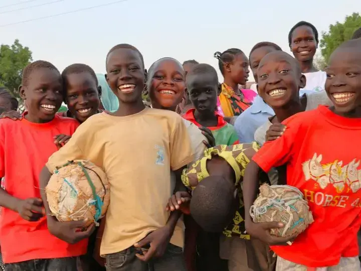 Smiling Sudanese boys with football