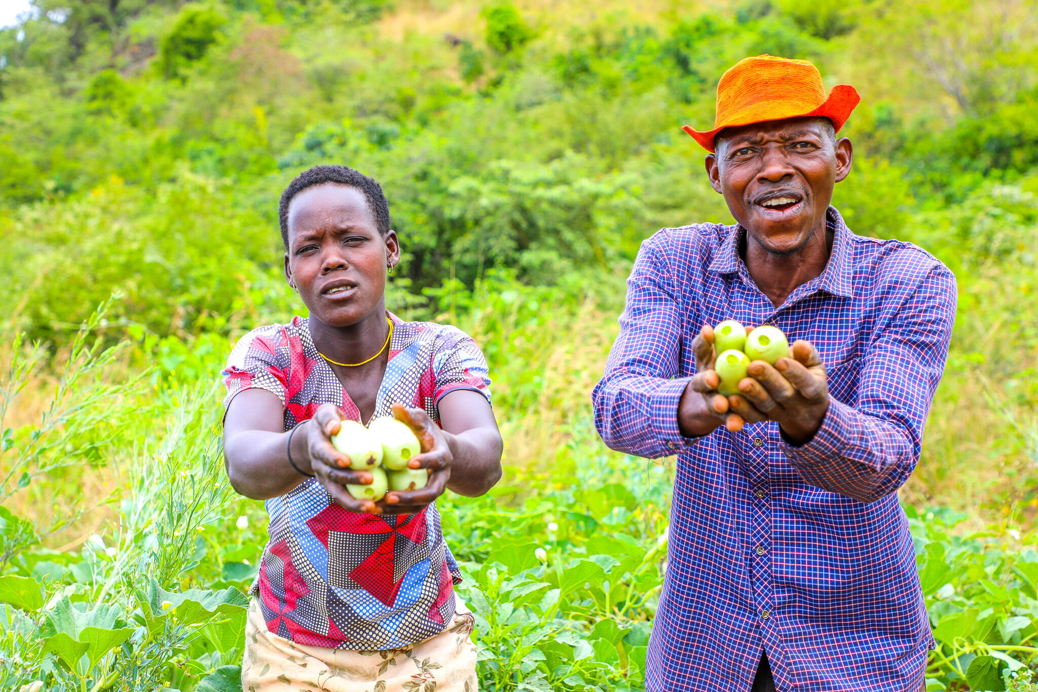 Babodmas and his wife dsiplay some of the food they harvested from the their garden.
