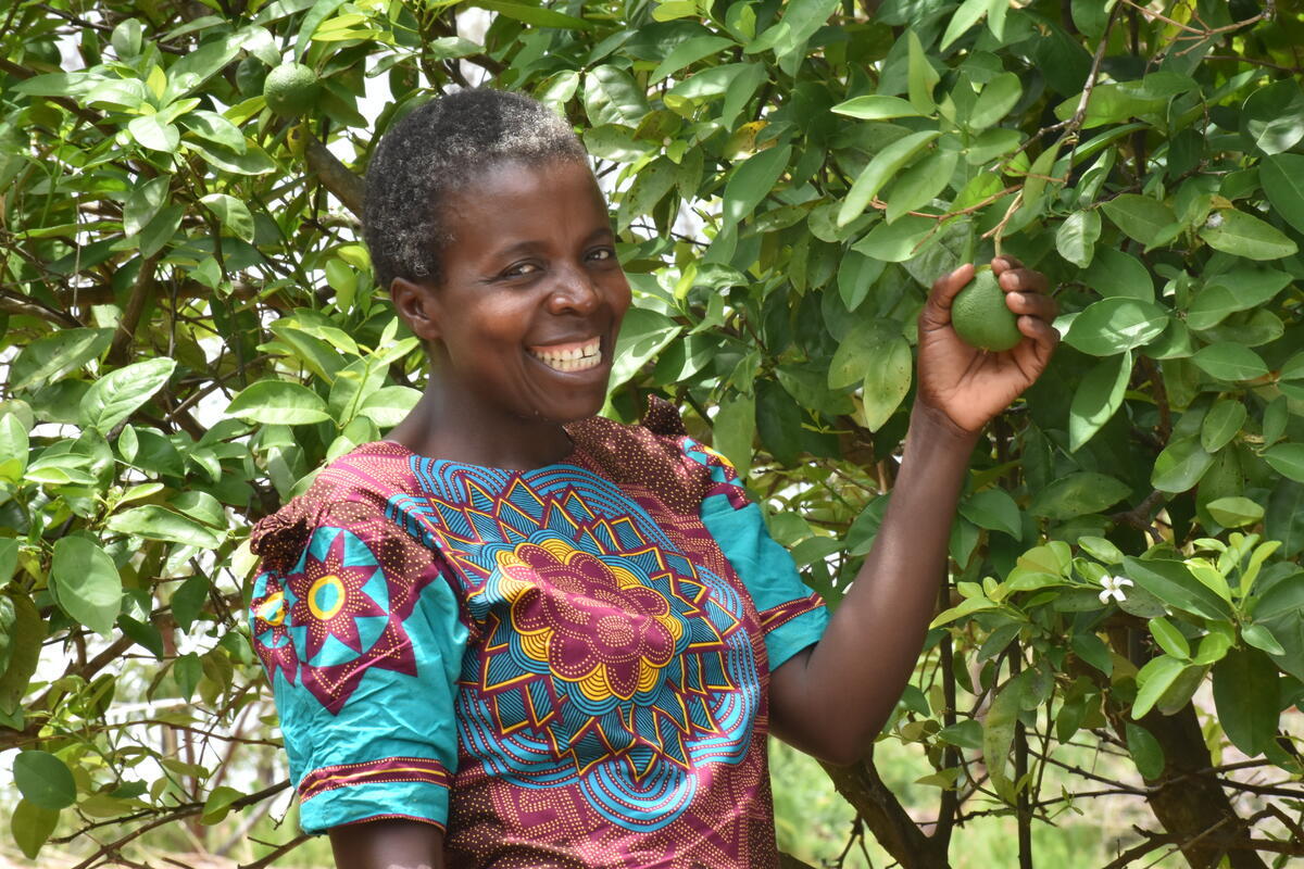 Zimba's wife, Georgina inspecting some of the fruit trees on the farm.
