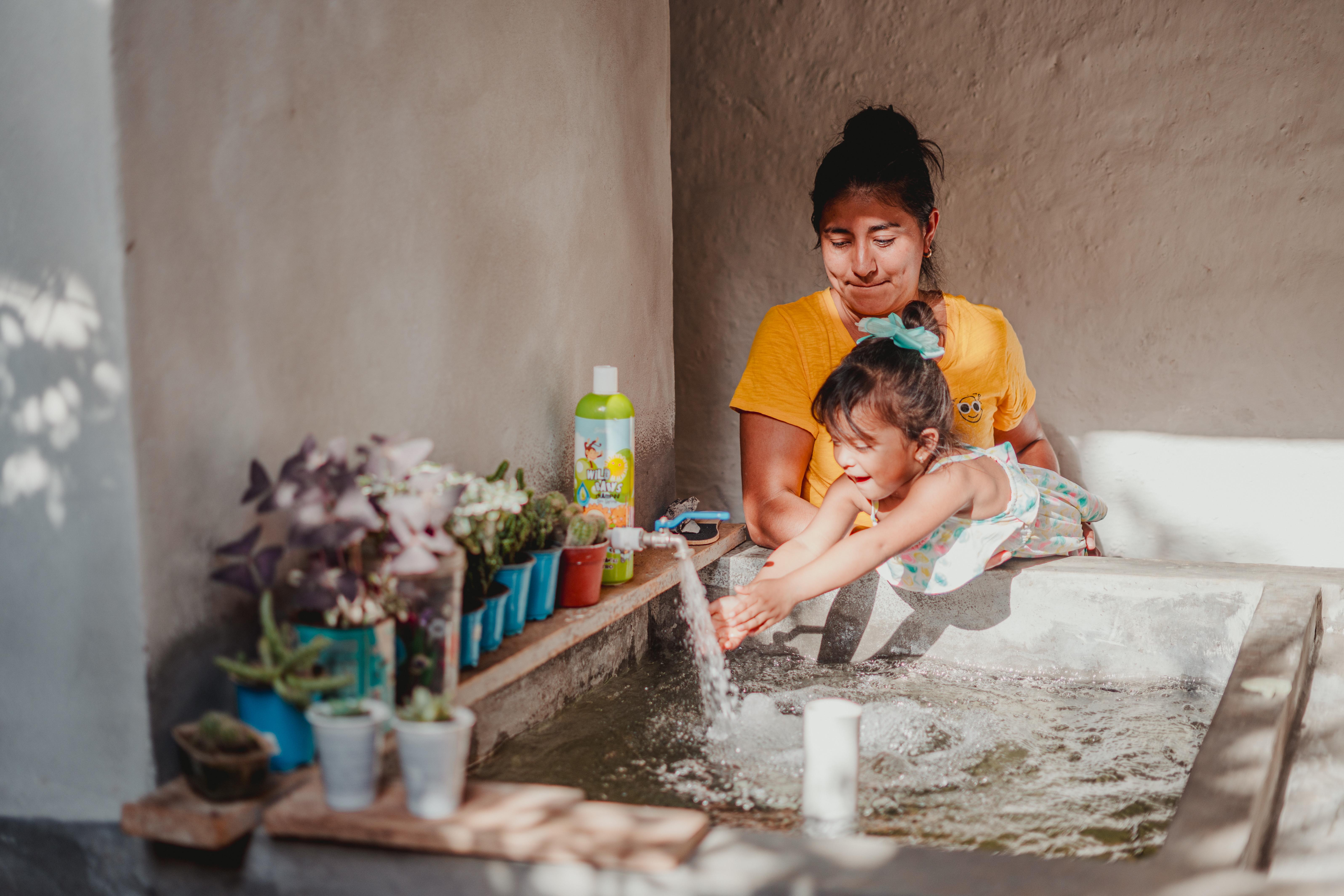 Karla and her daughter, Briana, 3, enjoy the clean running water that they now have access to at home.