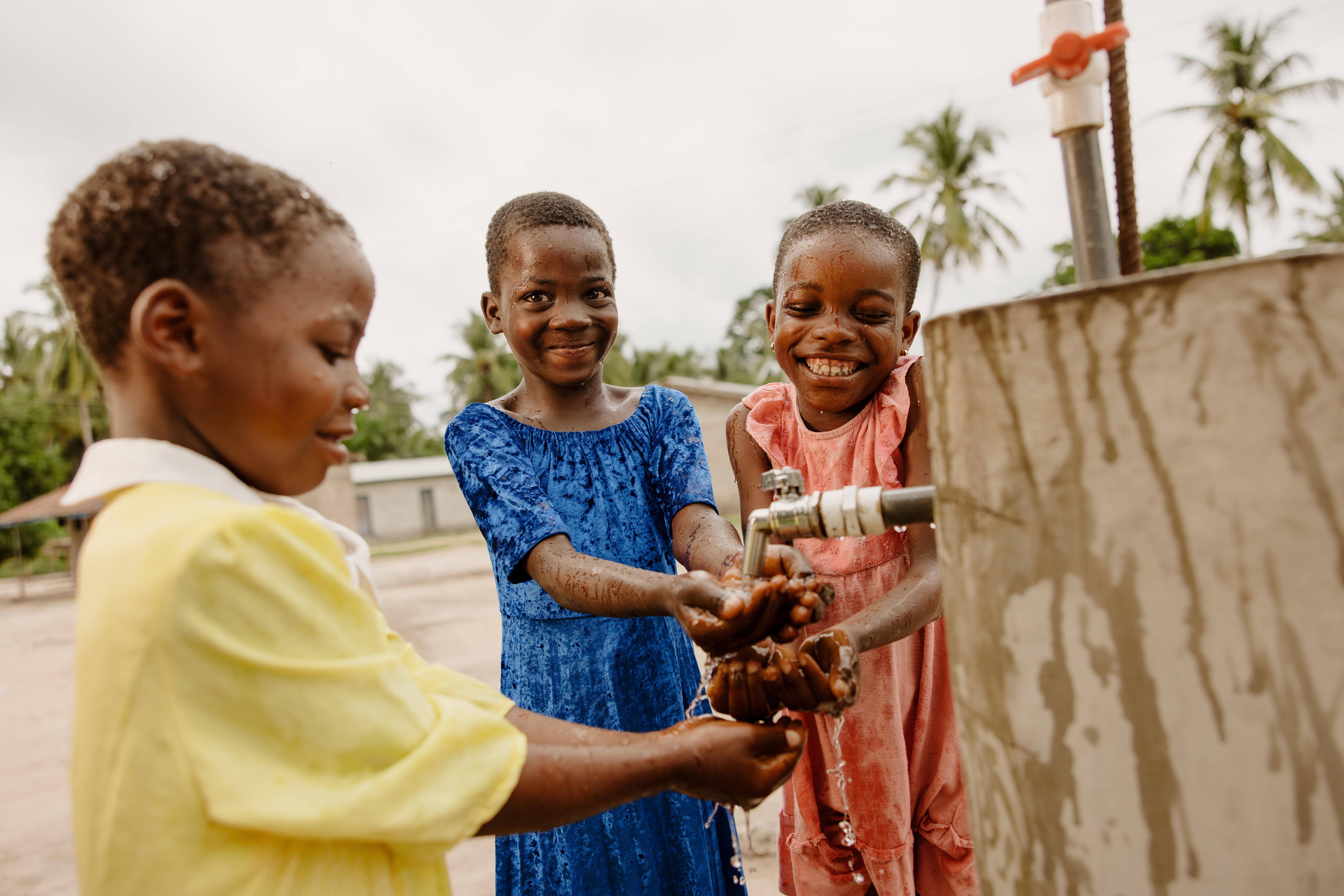 Children enjoy playing in clean water at their school thanks to new mechanised water system.