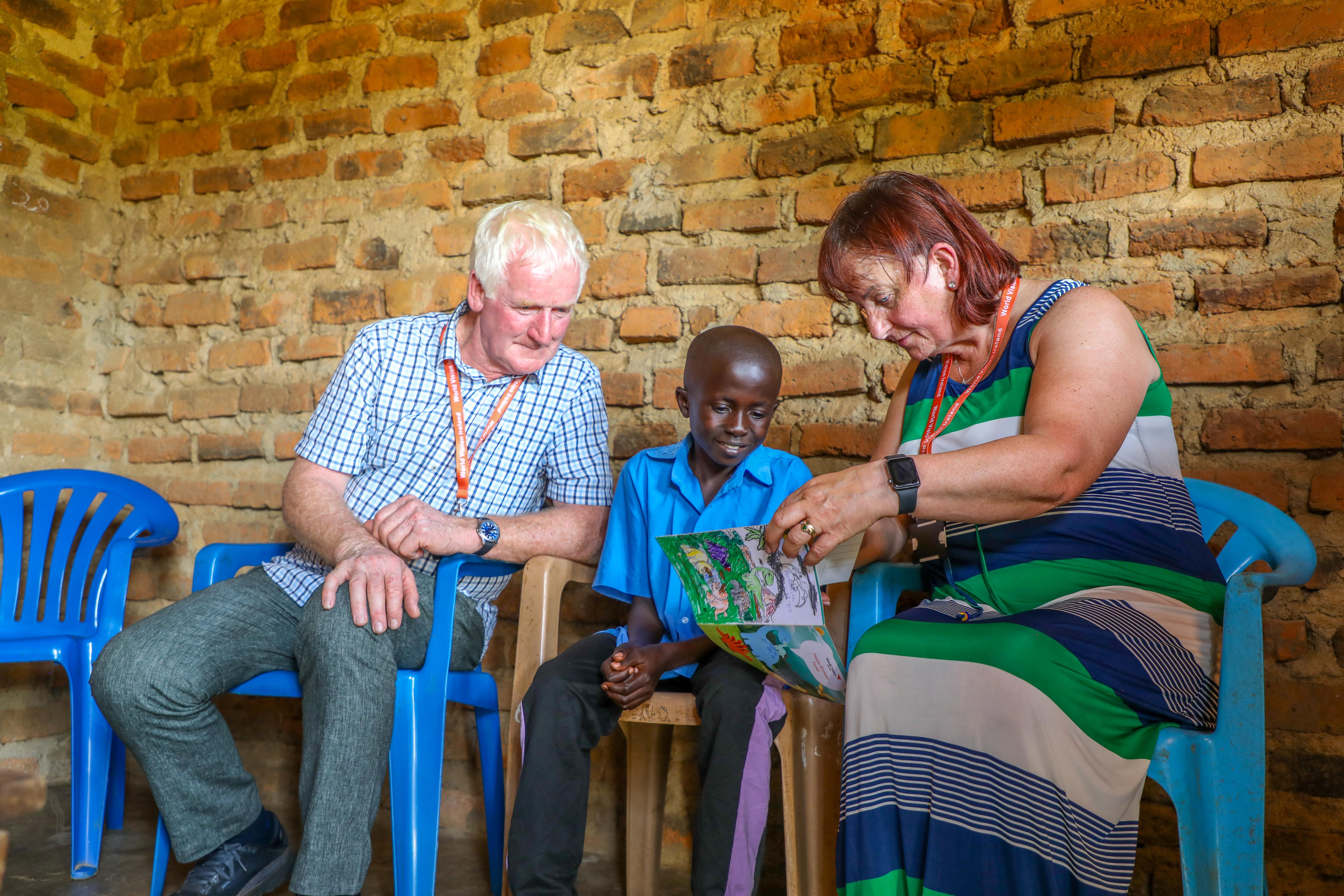 Sarah and John Osborne in Uganda with their sponsored child, Yazidi