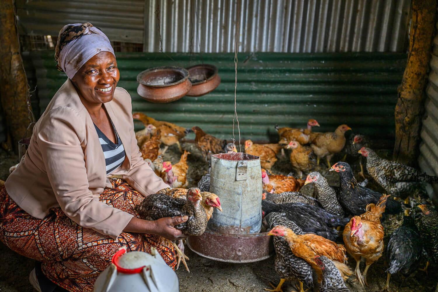 Anjela, Tanzania, feeds her chickens.